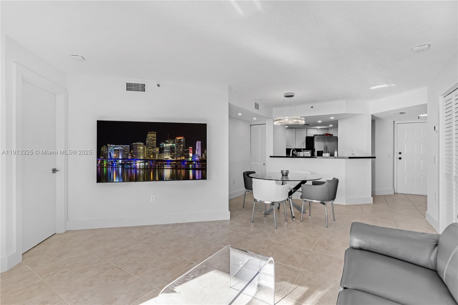 5880 Collins Avenue, Unit PH3 Miami Beach, FL 33140 - Photo 20 of 34 a living room with furniture and a kitchen view