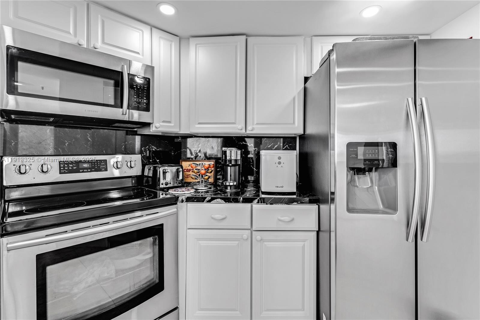 5880 Collins Avenue, Unit PH3 Miami Beach, FL 33140 - Photo 22 of 34 a kitchen with appliances a sink and cabinets