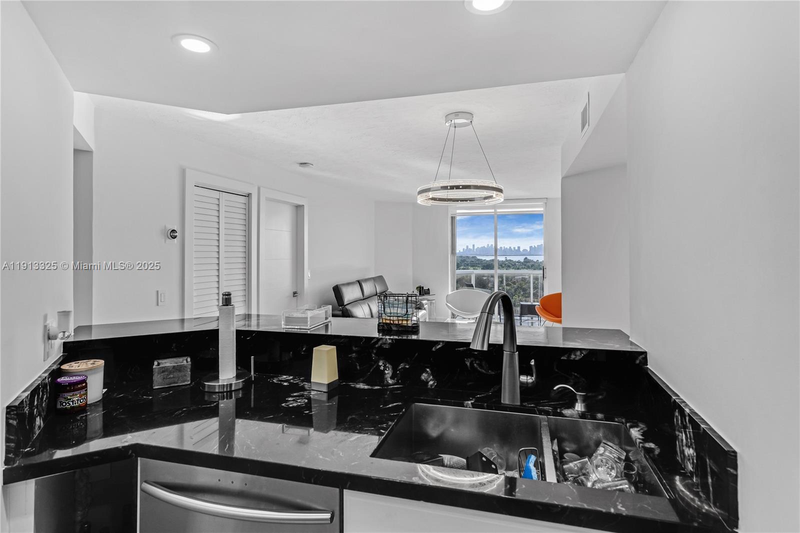 5880 Collins Avenue, Unit PH3 Miami Beach, FL 33140 - Photo 23 of 34 a kitchen with a sink and cabinets