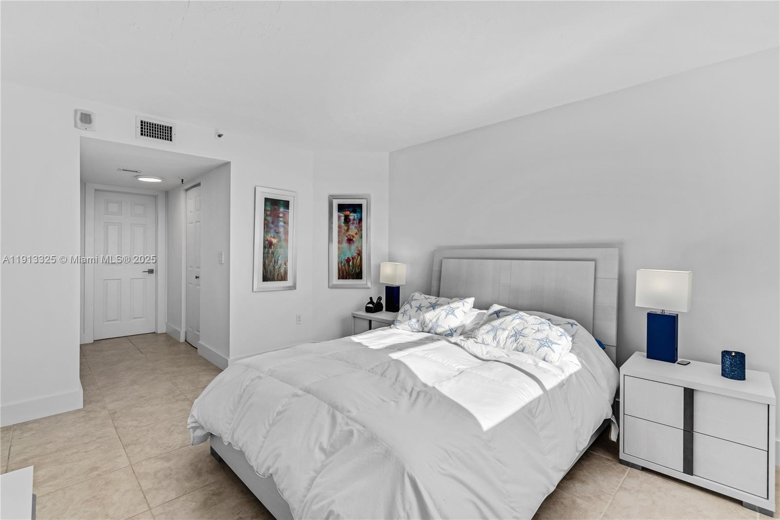 5880 Collins Avenue, Unit PH3 Miami Beach, FL 33140 - Photo 26 of 34 a bedroom with a bed and a lamp