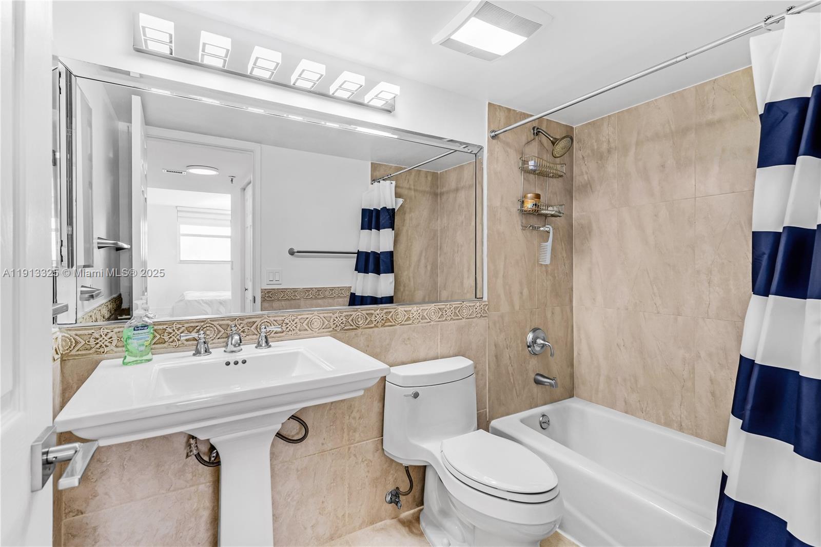 5880 Collins Avenue, Unit PH3 Miami Beach, FL 33140 - Photo 28 of 34 a bathroom with a sink a toilet a mirror a vanity and shower