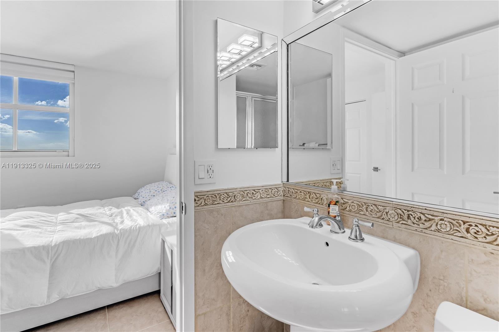 5880 Collins Avenue, Unit PH3 Miami Beach, FL 33140 - Photo 34 of 34 a en suite bathroom with a double vanity sink and mirror