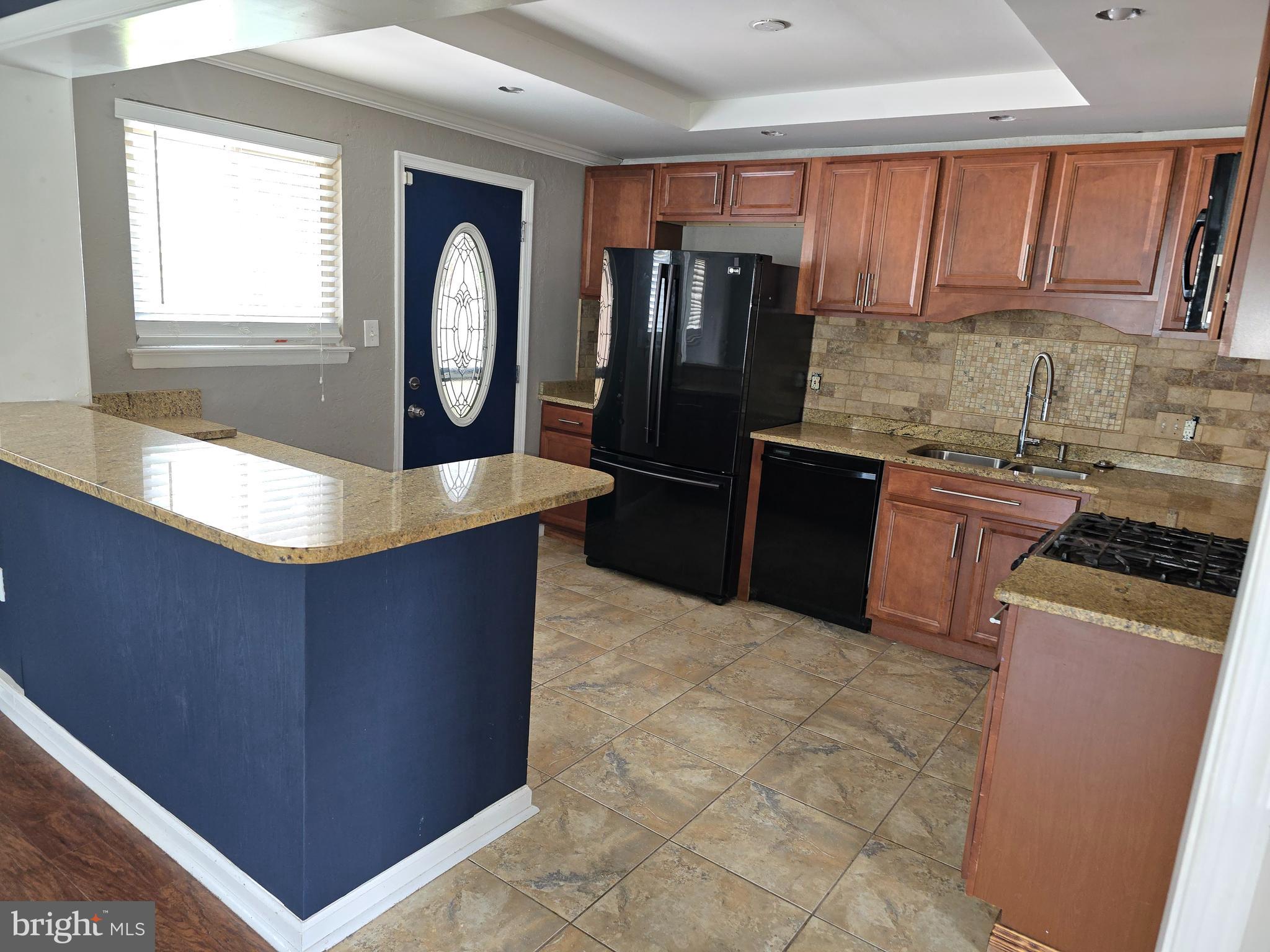 8343 Scotts Level Road Pikesville, MD 21208 - Photo 12 of 33 a kitchen with granite countertop a stove a refrigerator and wooden cabinets