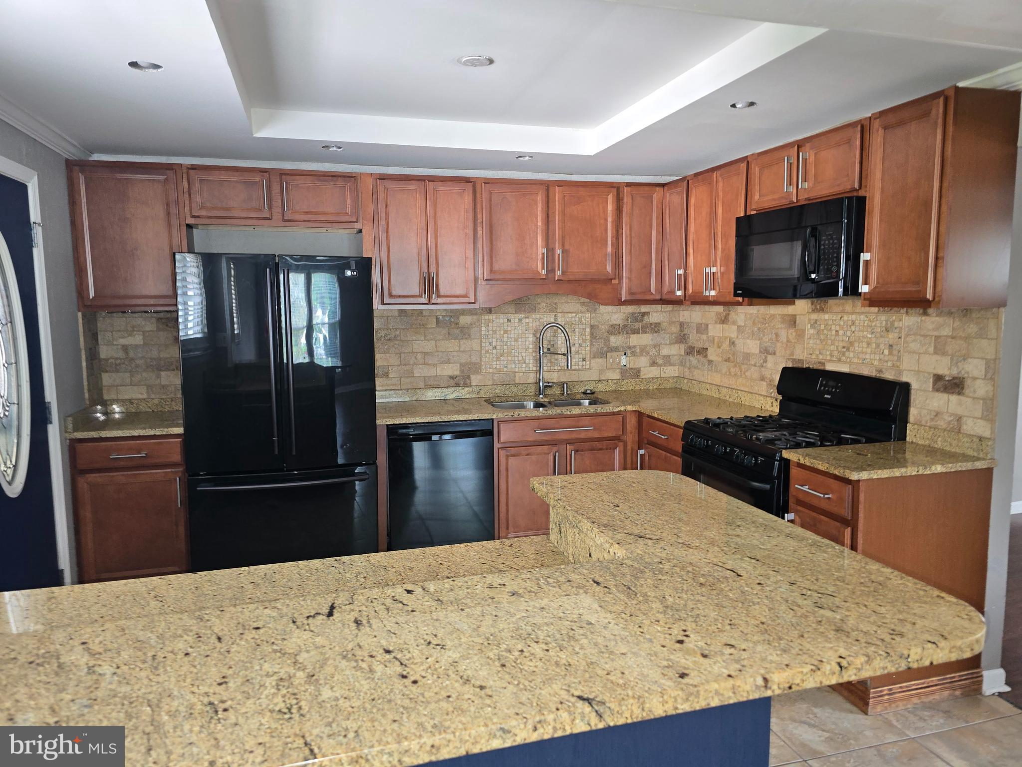 8343 Scotts Level Road Pikesville, MD 21208 - Photo 14 of 33 a kitchen with granite countertop a refrigerator stove top oven and sink