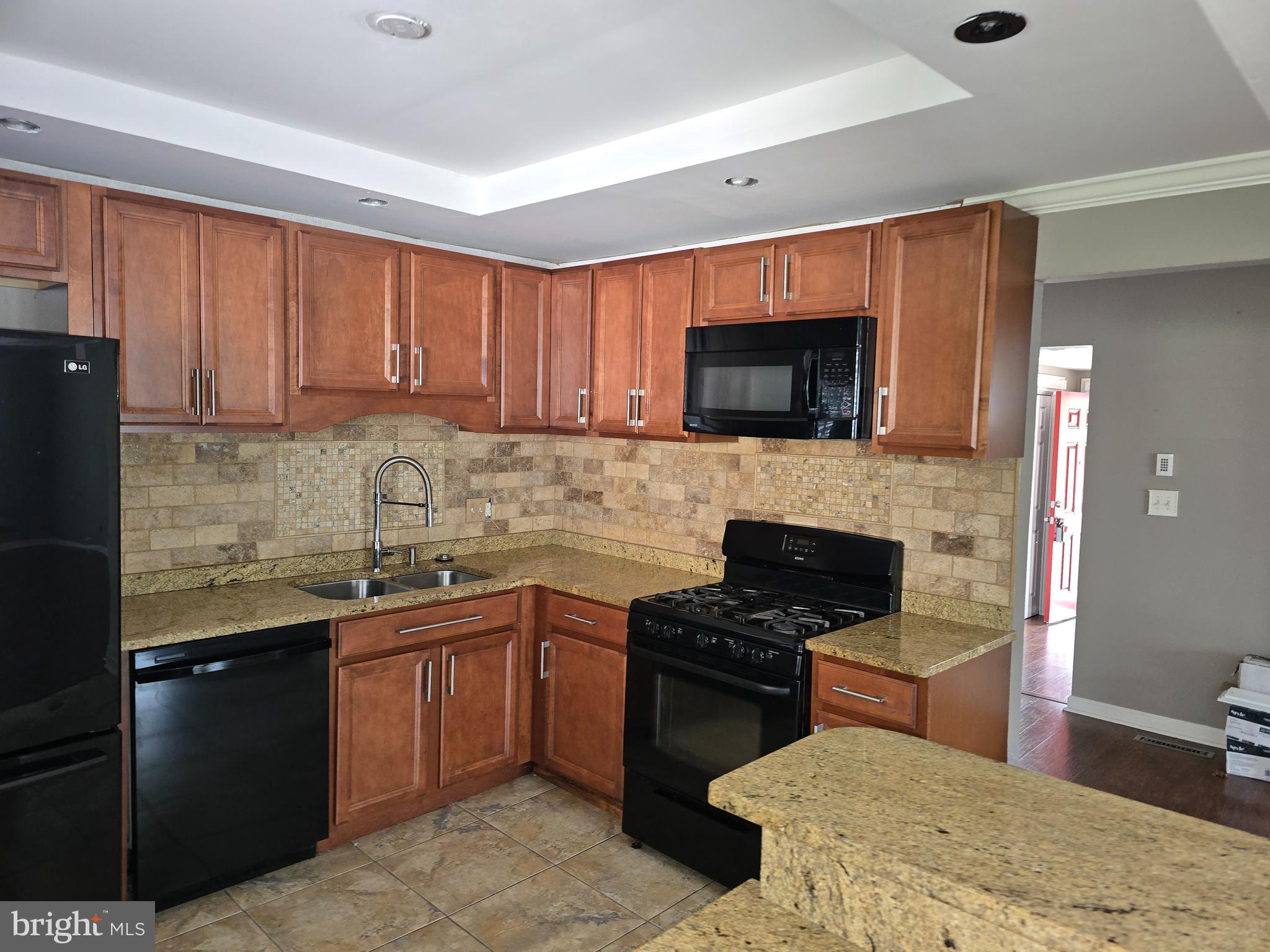 8343 Scotts Level Road Pikesville, MD 21208 - Photo 15 of 33 a kitchen with stainless steel appliances granite countertop a stove a sink and a microwave