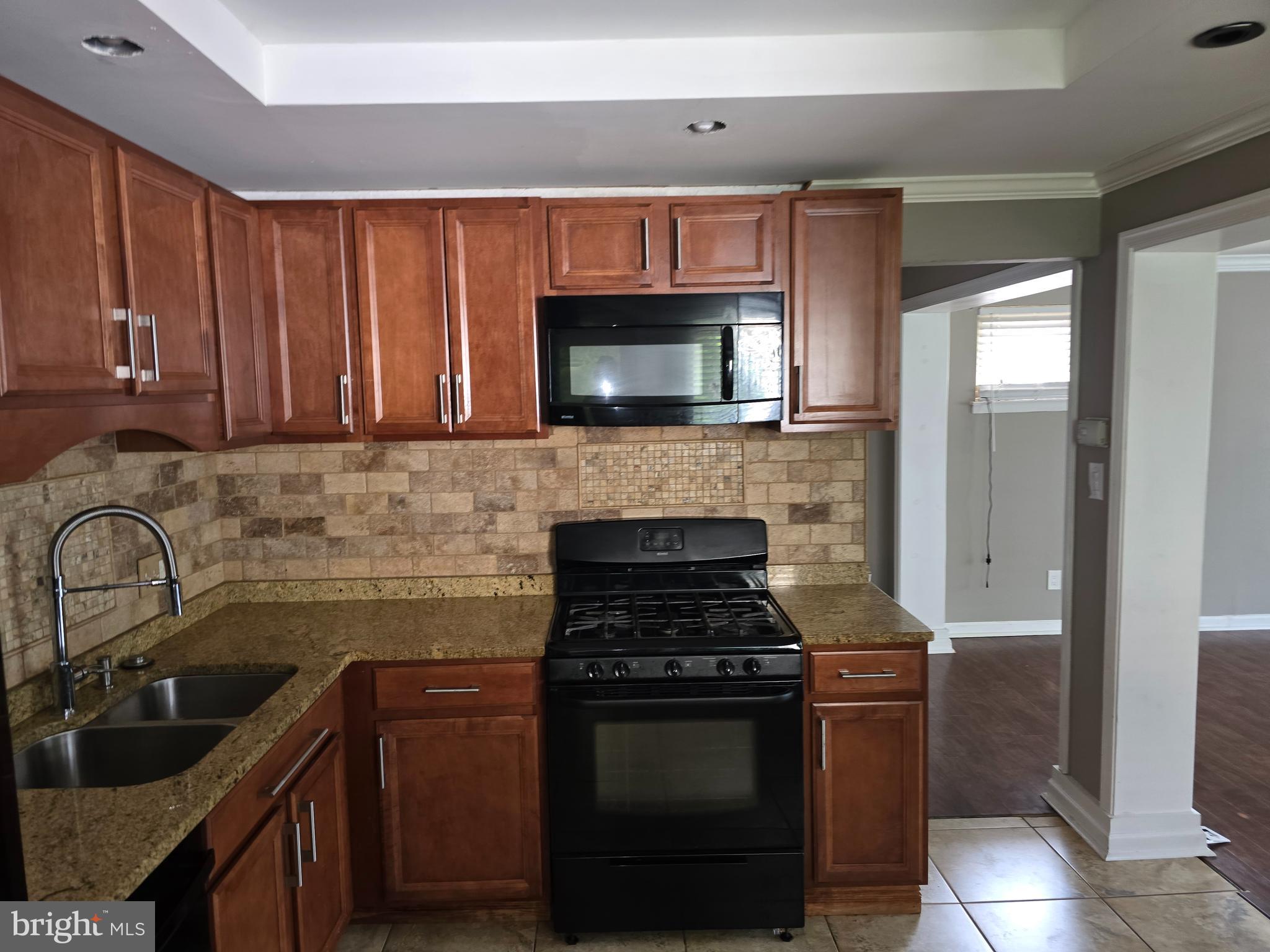 8343 Scotts Level Road Pikesville, MD 21208 - Photo 16 of 33 a kitchen with granite countertop a stove and a sink with granite countertops