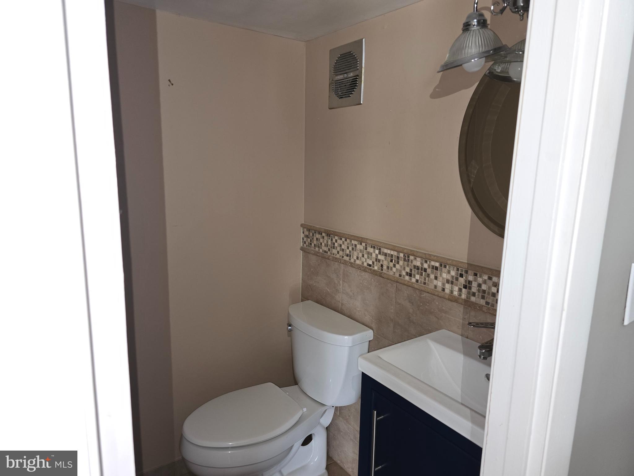 8343 Scotts Level Road Pikesville, MD 21208 - Photo 23 of 33 a white toilet sitting next to a bathroom sink