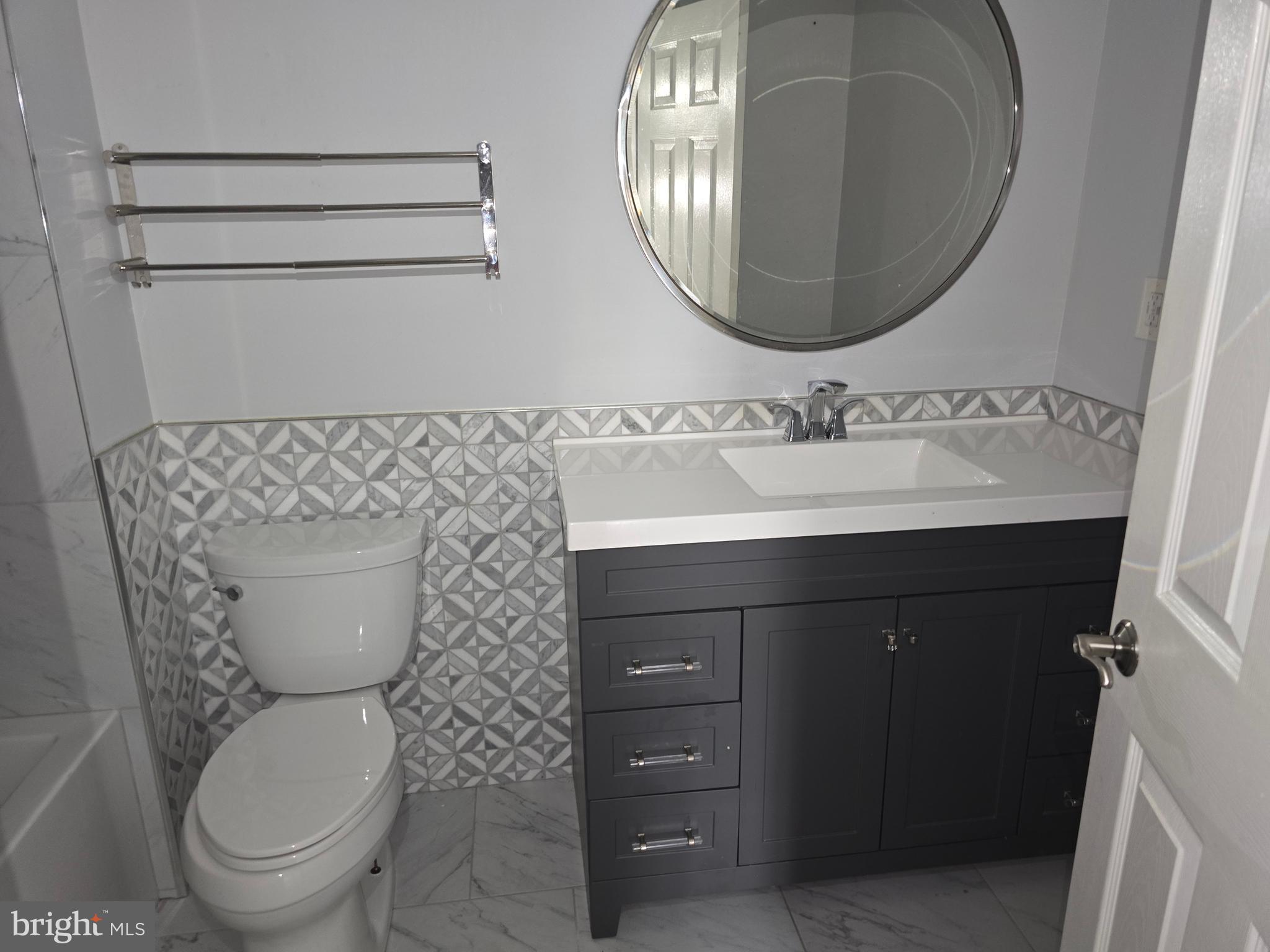 8343 Scotts Level Road Pikesville, MD 21208 - Photo 25 of 33 a bathroom with a toilet a sink and mirror