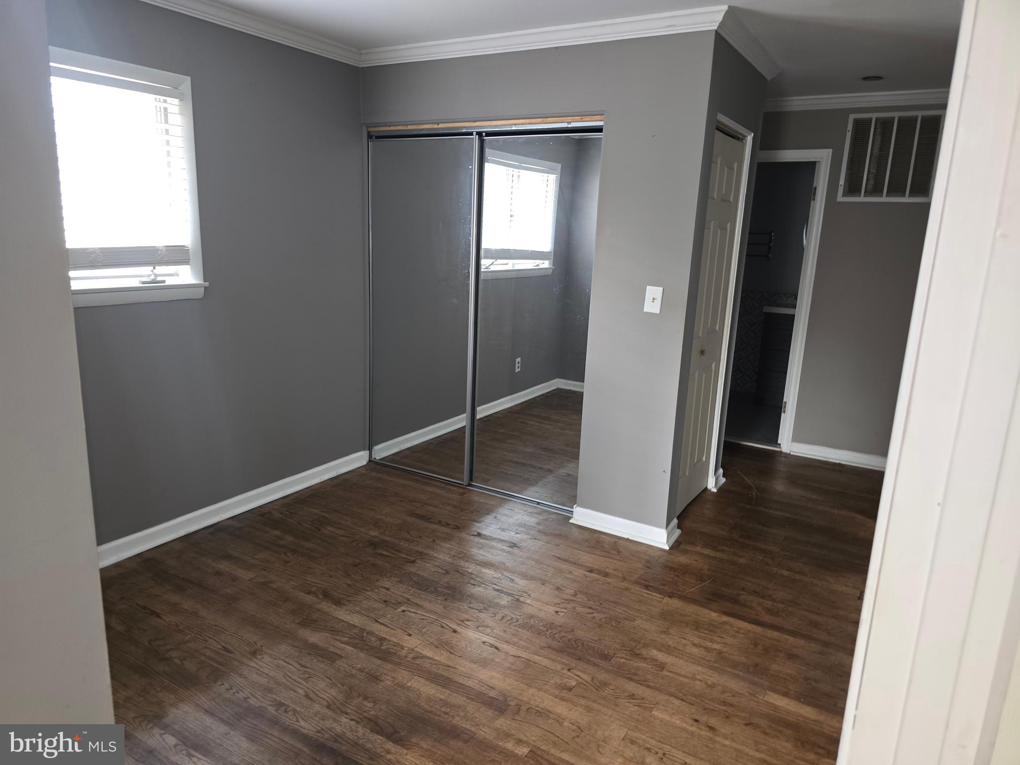 8343 Scotts Level Road Pikesville, MD 21208 - Photo 33 of 33 an empty room with wooden floor and a window