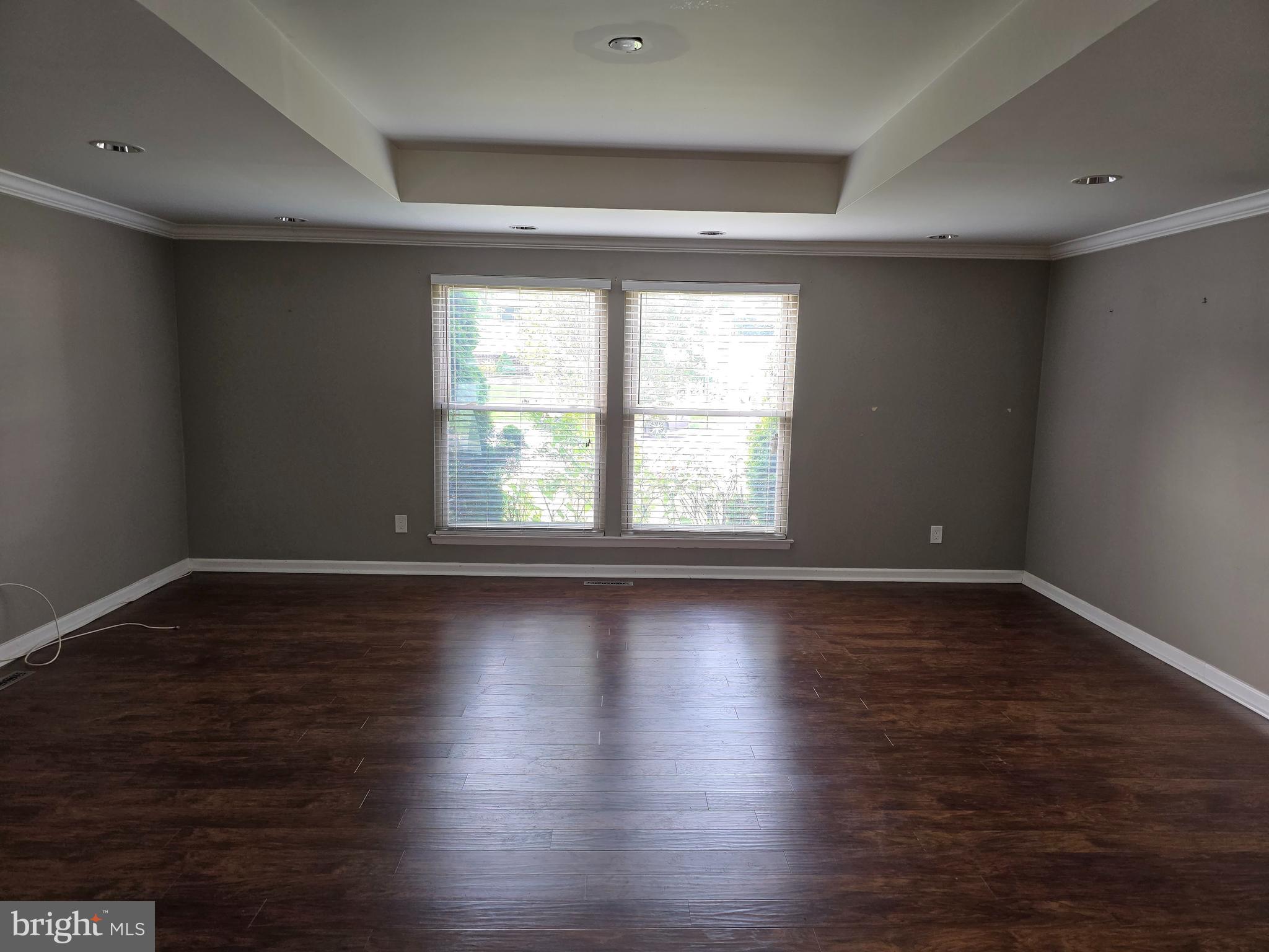 8343 Scotts Level Road Pikesville, MD 21208 - Photo 10 of 33 a view of an empty room with wooden floor and a window