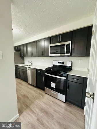 a kitchen with a sink a refrigerator and a microwave