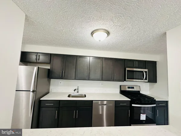 a view of a kitchen with a sink stove and refrigerator