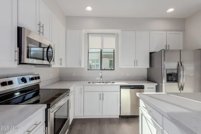 a kitchen with stainless steel appliances a refrigerator stove microwave and sink