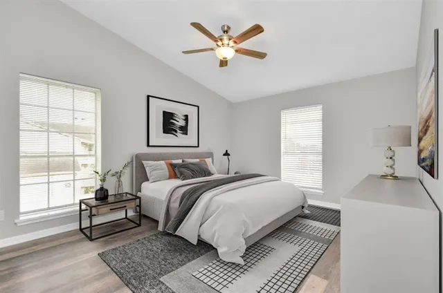 a bedroom with a bed and a window with a potted plant on a dresser