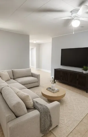 a living room with furniture a flat screen tv and a window