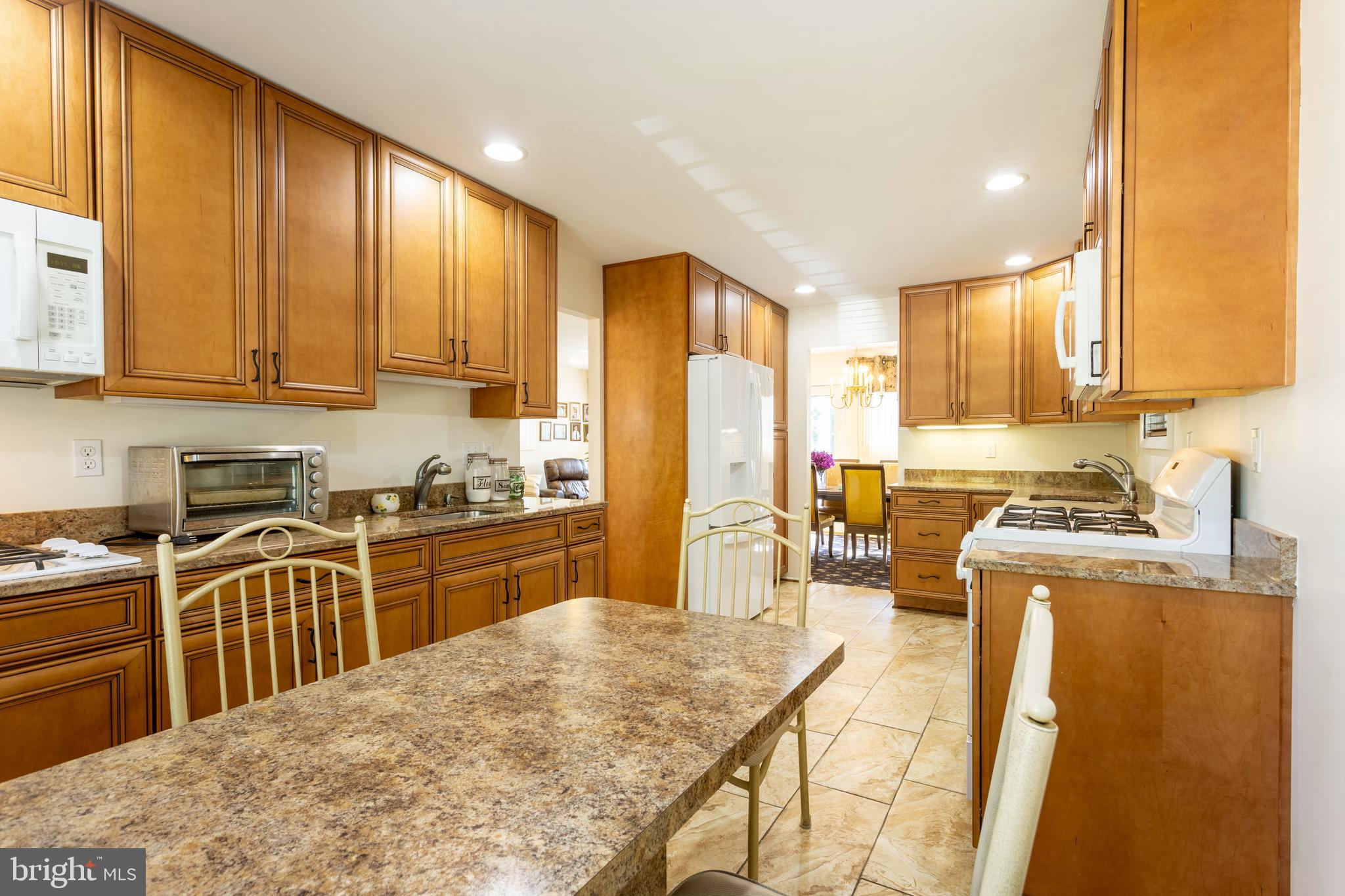 3313 Claran Road Baltimore, MD 21215 - Photo 11 of 35 a kitchen with stainless steel appliances granite countertop a stove top oven a sink a refrigerator white cabinets and wooden floor