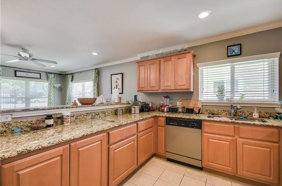 3009 Speedway, Unit 2 Austin, TX 78705 - Photo 10 of 10 This kitchen showcases ample granite counters and warm wood cabinetry, offering a seamless flow to adjacent living areas.