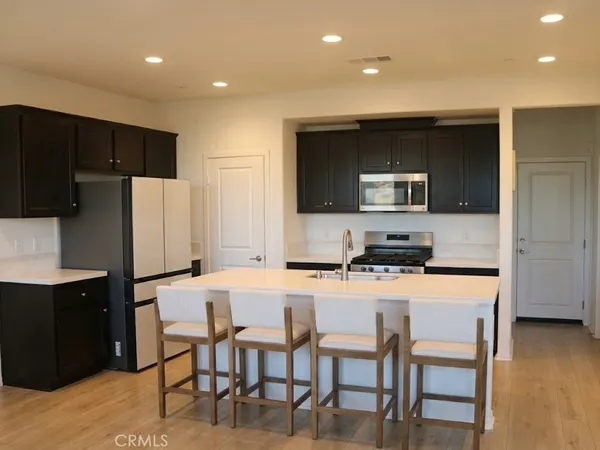 a kitchen with a table chairs refrigerator and microwave