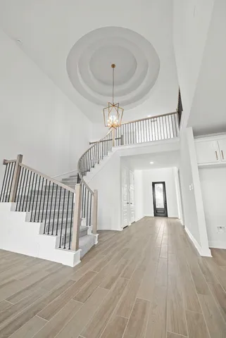 a view of a hallway with wooden floor and staircase