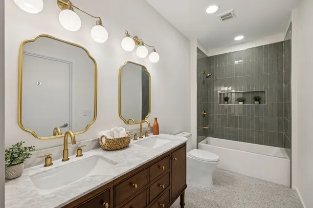 a bathroom with a double vanity sink toilet and shower