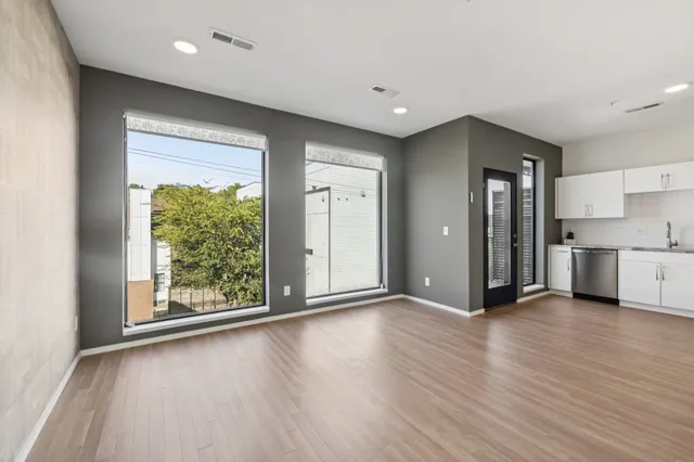 a view of a kitchen with a fridge and wooden floor