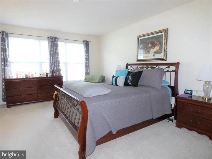 4911 Potomac Highlands Circle Triangle, VA 22172 - Photo 2 of 14 a bed sitting in a bedroom next to a window