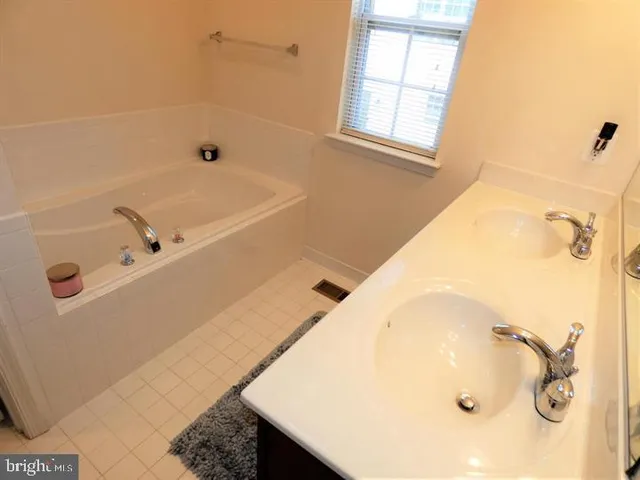 a bathroom with a tub a sink and a window