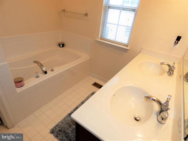 4911 Potomac Highlands Circle Triangle, VA 22172 - Photo 4 of 14 a bathroom with a tub a sink and a window