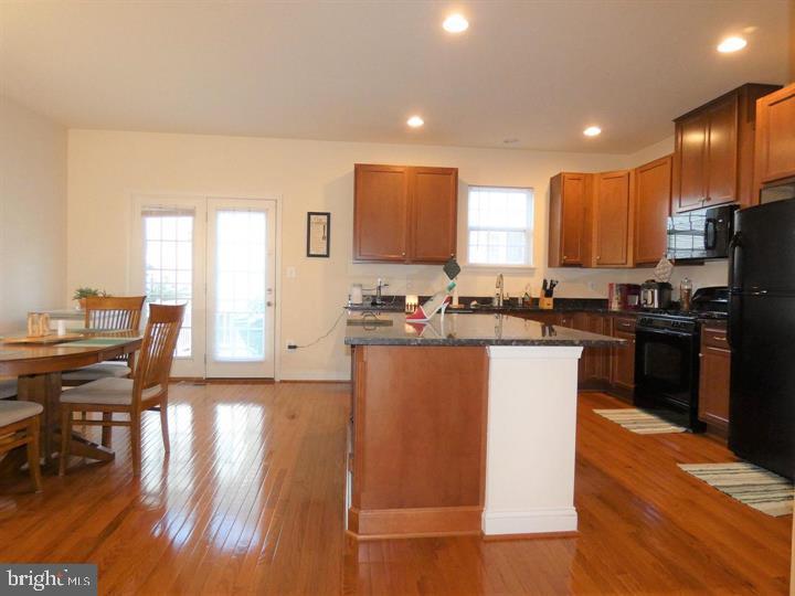 4911 Potomac Highlands Circle Triangle, VA 22172 - Photo 5 of 14 a kitchen with granite countertop a stove a sink a refrigerator and blue cabinets with wooden floor