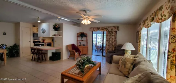 a living room with furniture a large window and a chandelier