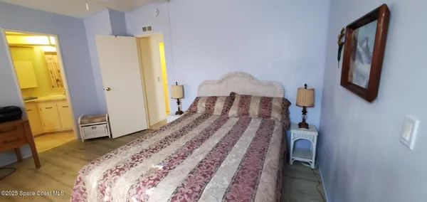 a bedroom with a bed and a flat tv screen on dresser