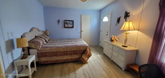 a bedroom with a bed wooden floor and lamp