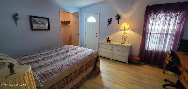 a bedroom with a bed and a mirror on the dresser
