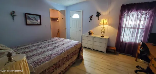 a bedroom with a bed and a mirror on the dresser