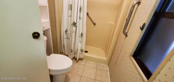 a bathroom with a toilet and a shower