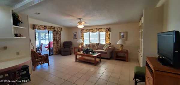 a living room with furniture a window and a flat screen tv