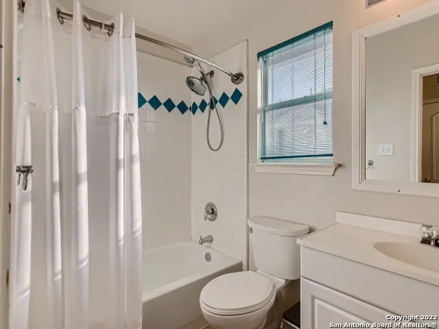 a bathroom with a toilet sink vanity tub and shower