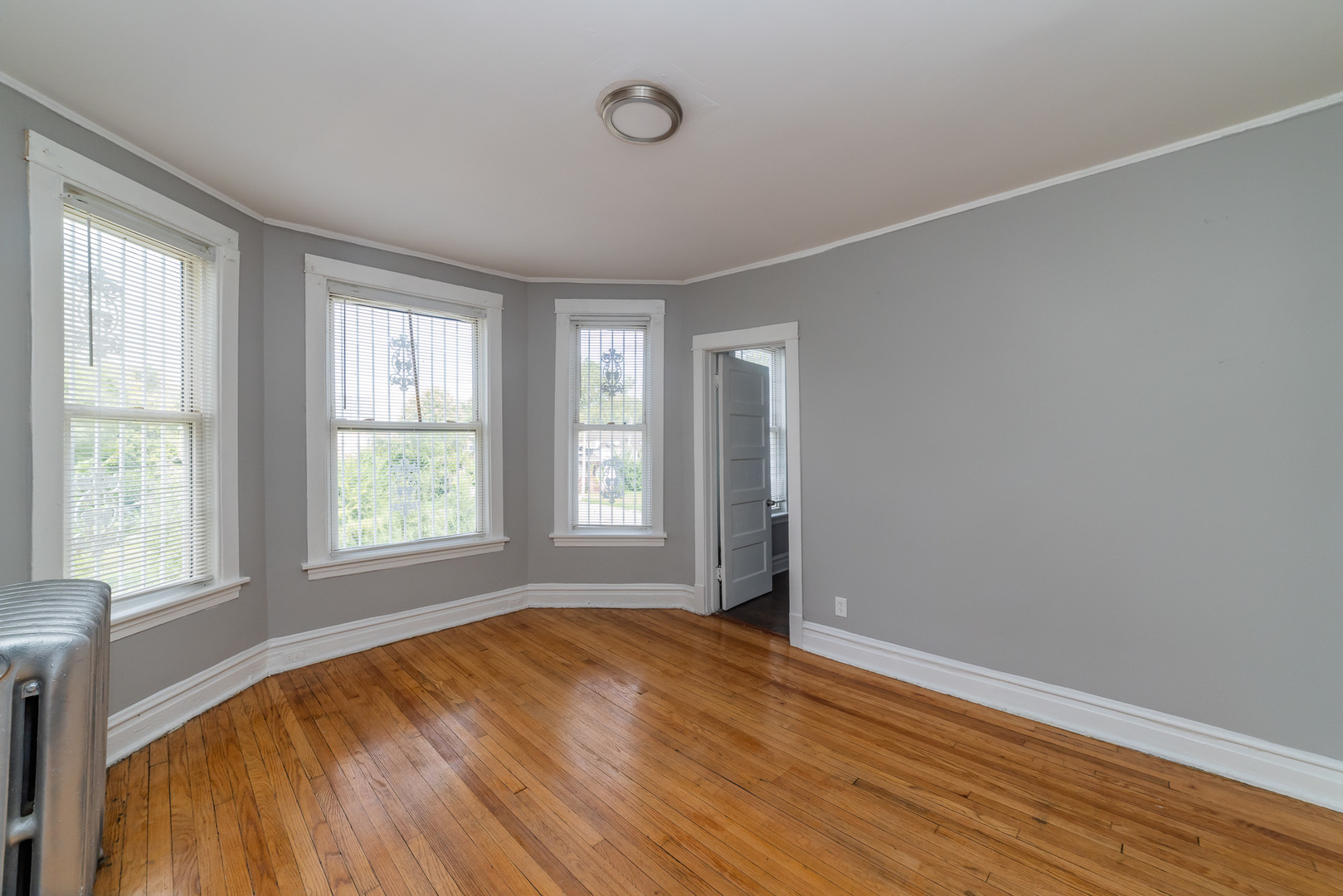 1229 East 71st Street Chicago, IL 60619 - Photo 2 of 14 an empty room with wooden floor and windows