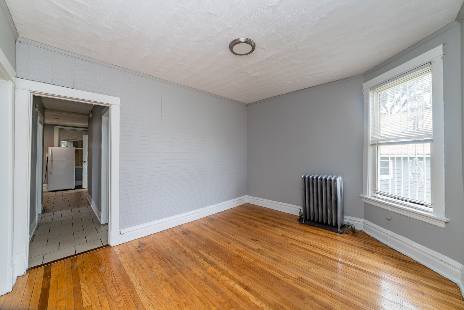 1229 East 71st Street Chicago, IL 60619 - Photo 4 of 14 a view of empty room with wooden floor and fan