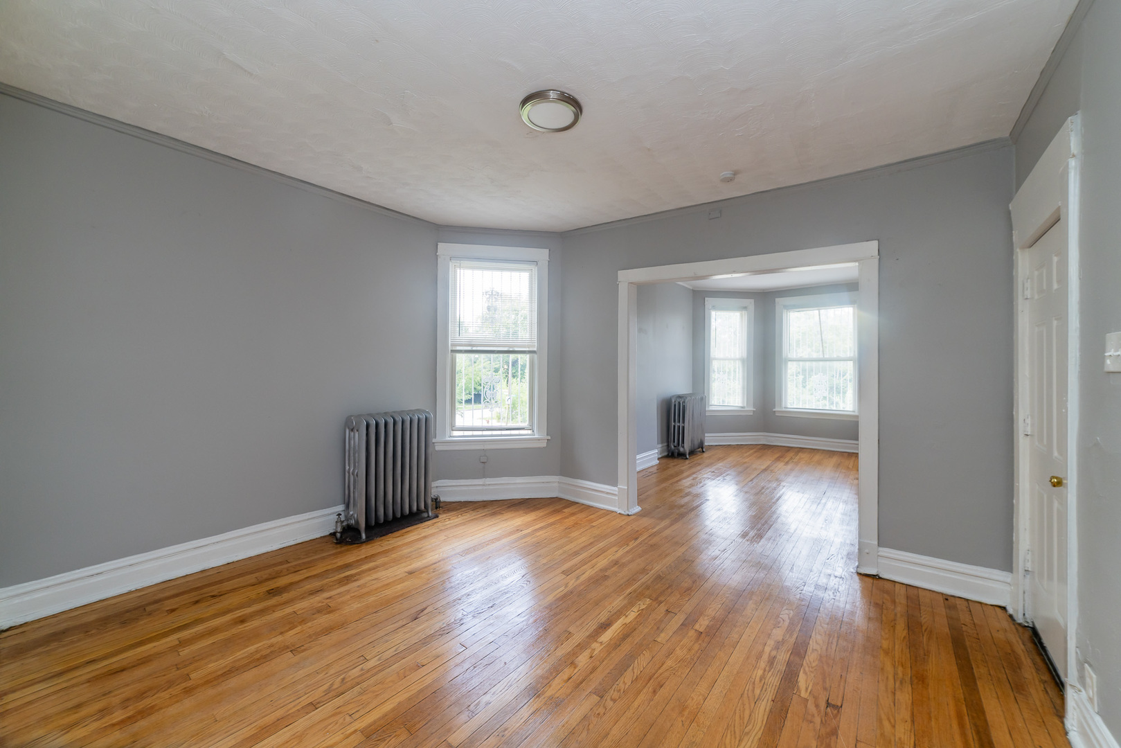 1229 East 71st Street Chicago, IL 60619 - Photo 5 of 14 a view of an empty room with wooden floor and a window