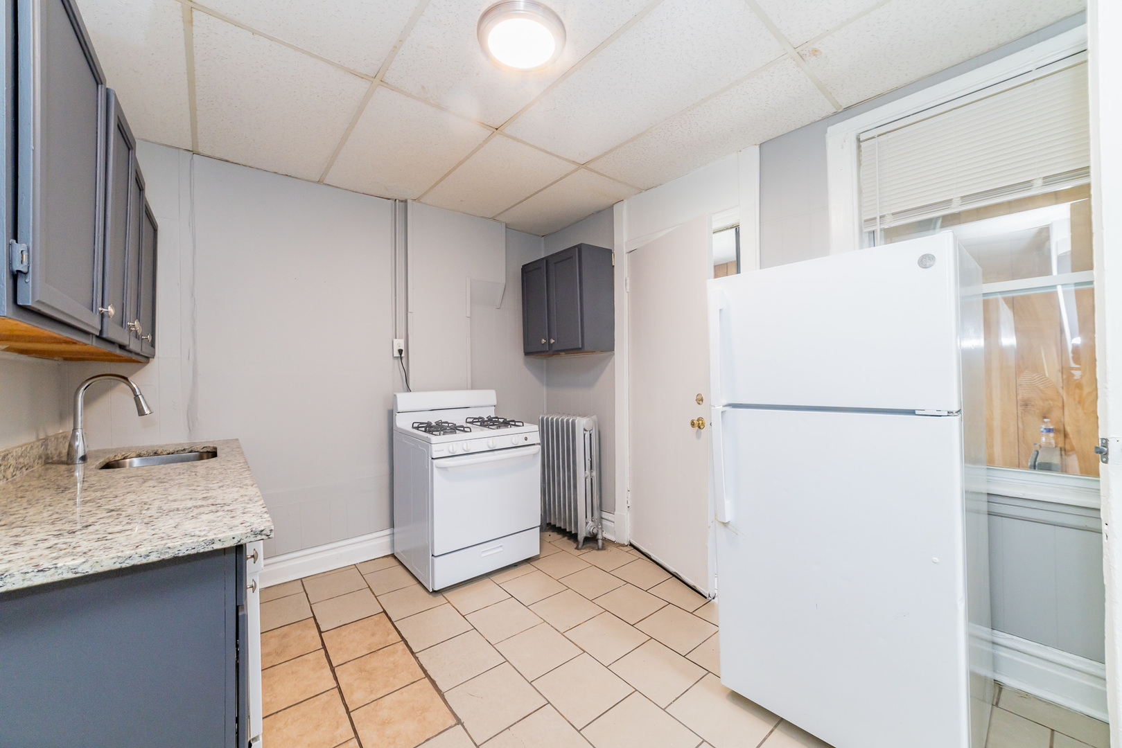 1229 East 71st Street Chicago, IL 60619 - Photo 6 of 14 a kitchen with a refrigerator sink stove and cabinets
