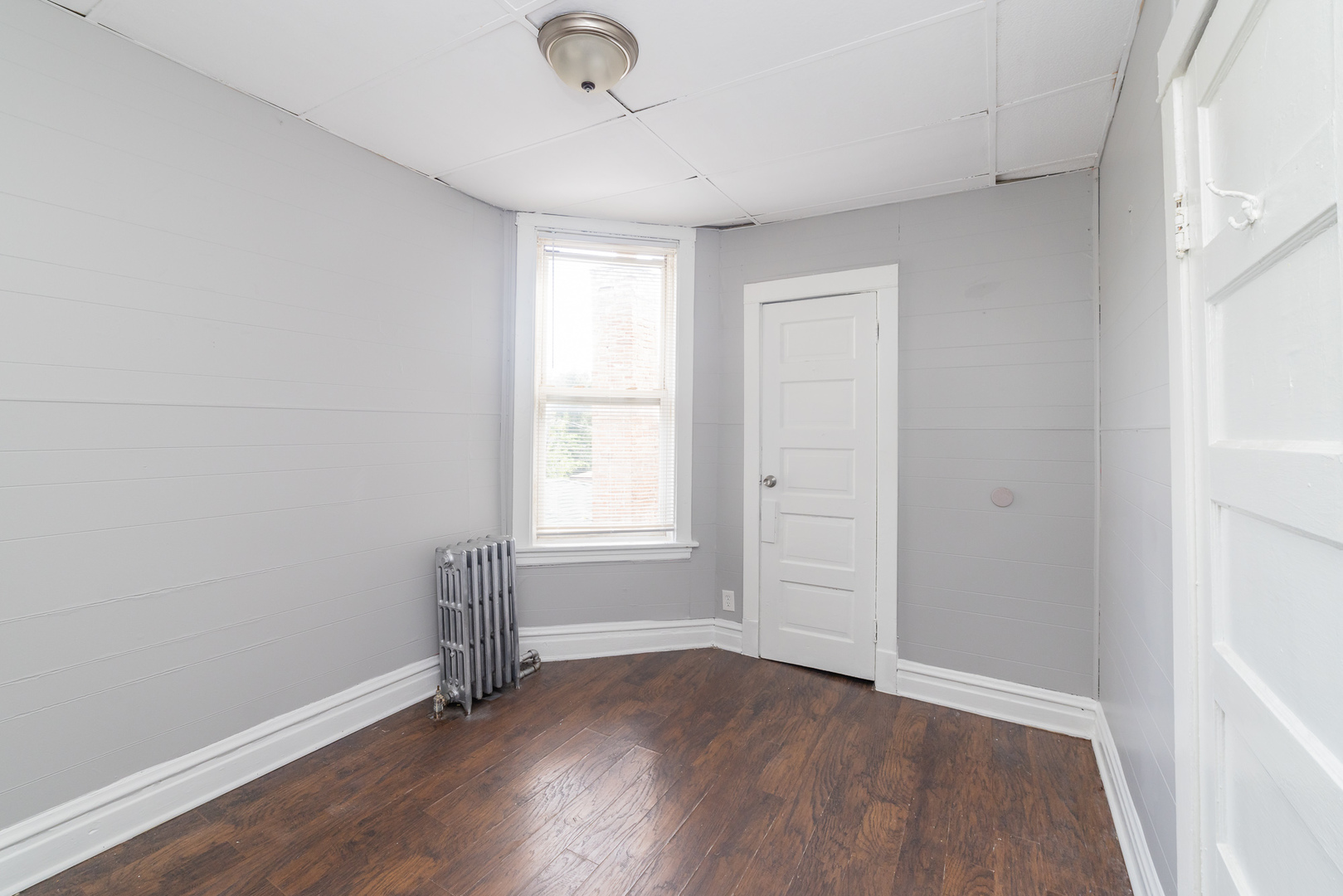 1229 East 71st Street Chicago, IL 60619 - Photo 8 of 14 an empty room with wooden floor and windows