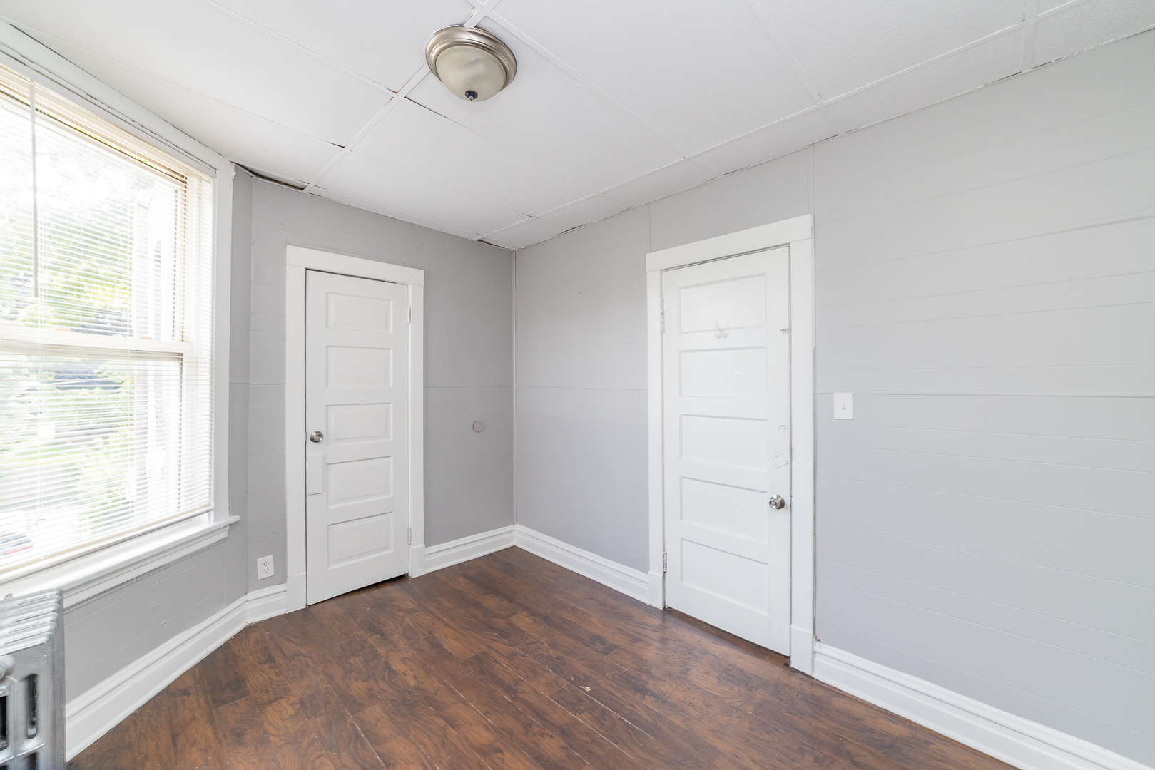 1229 East 71st Street Chicago, IL 60619 - Photo 9 of 14 an empty room with wooden floor and windows