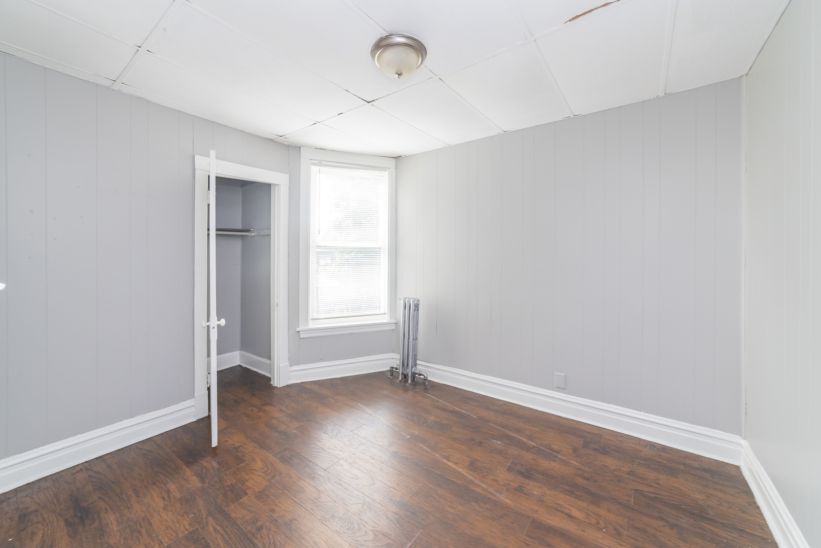 1229 East 71st Street Chicago, IL 60619 - Photo 10 of 14 an empty room with wooden floor and windows