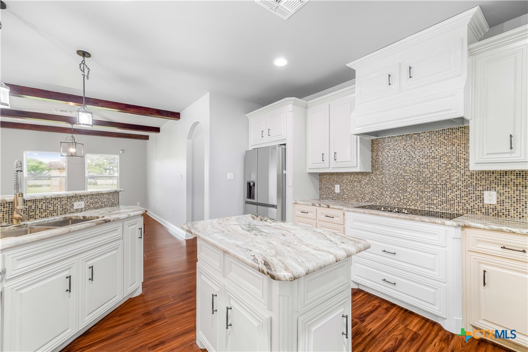 204 James Street Inez, TX 77968 - Photo 12 of 35 a kitchen with granite countertop kitchen island wooden cabinets and white appliances