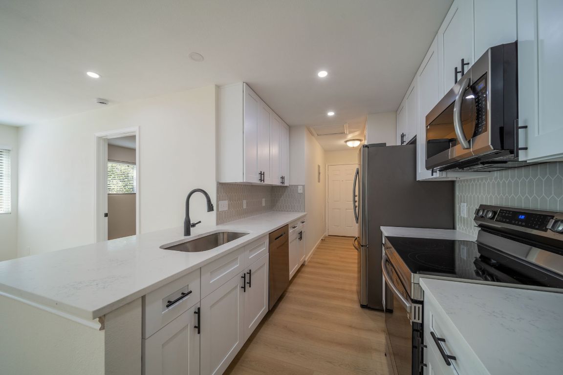 5005 Cape Verde Cove, Unit A Austin, TX 78744 - Photo 1 of 1 a kitchen with stainless steel appliances granite countertop a sink stove and refrigerator