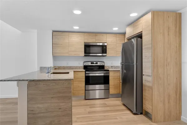 wooden floor in an empty room with a kitchen