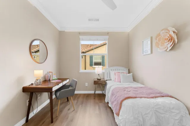 a bedroom with a bed window and a table in it