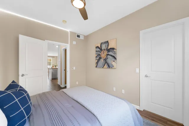 a bedroom with a bed and painting on the wall