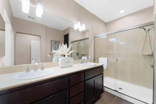 a bathroom with a double vanity sink mirror double and shower